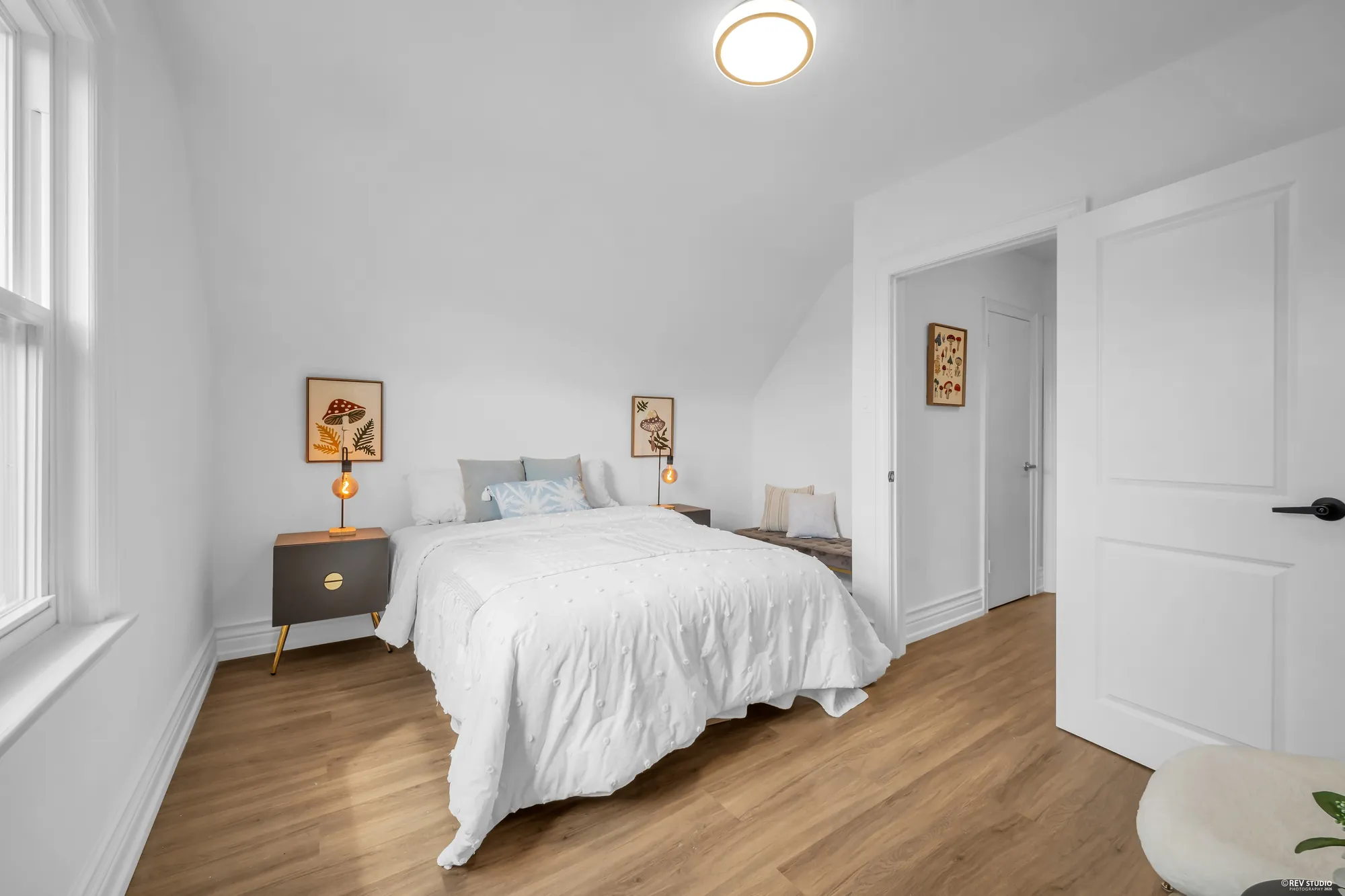 The second upstairs bedroom with a window at the gable end and a sloped ceiling