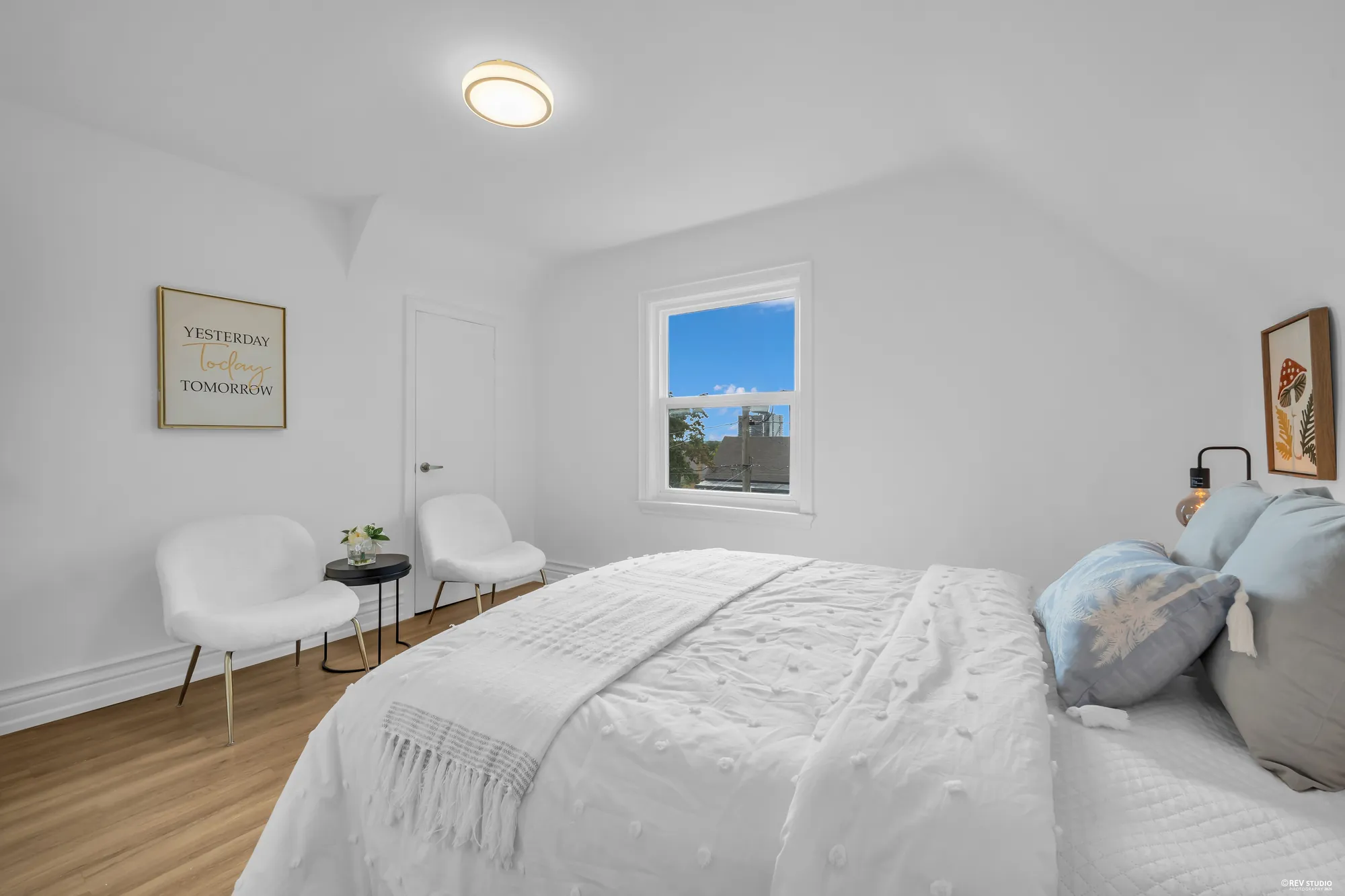 The second upstairs bedroom from the far end, with room for two chairs beside the window