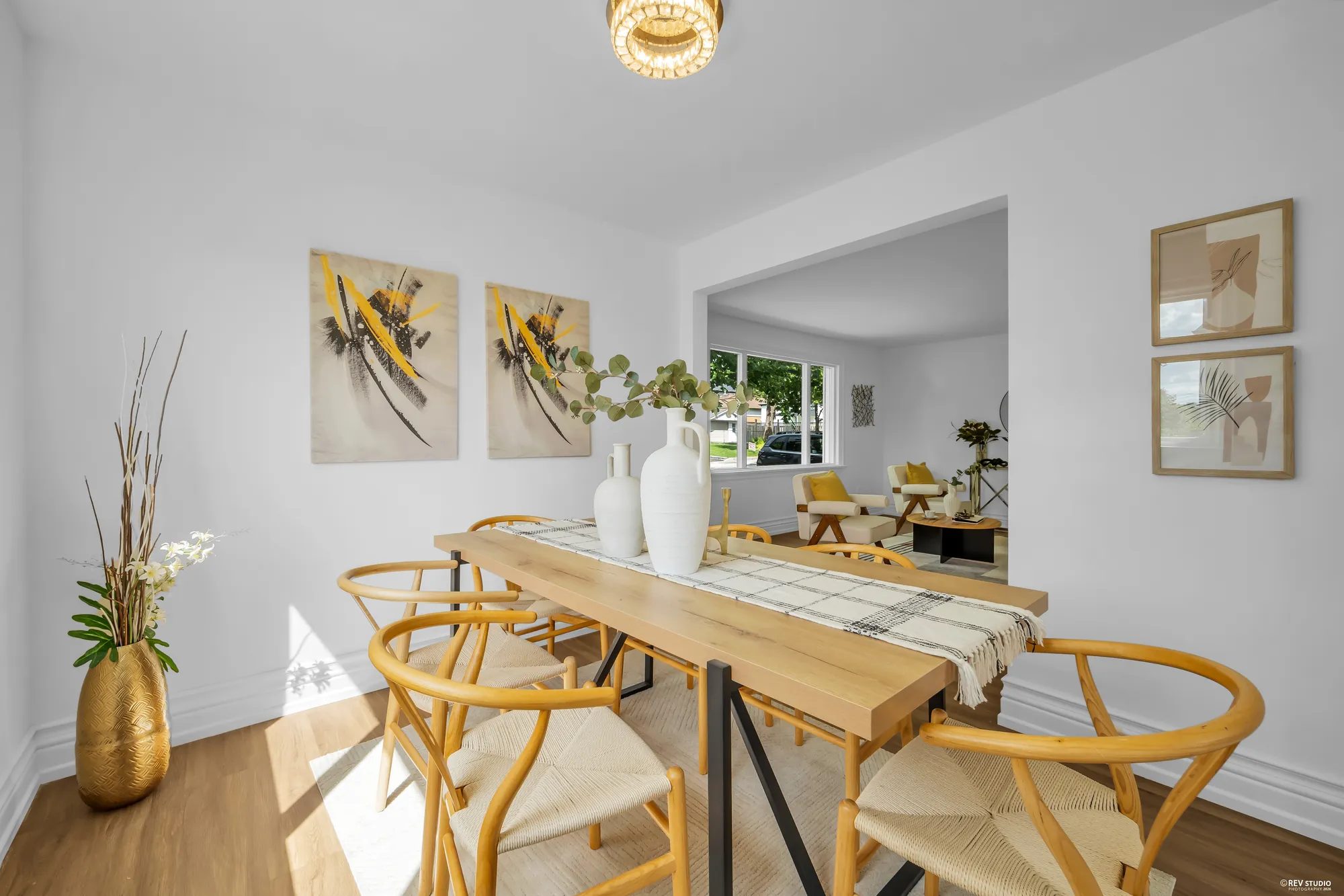 The dining room with a wood table and six chairs, open to the living room
