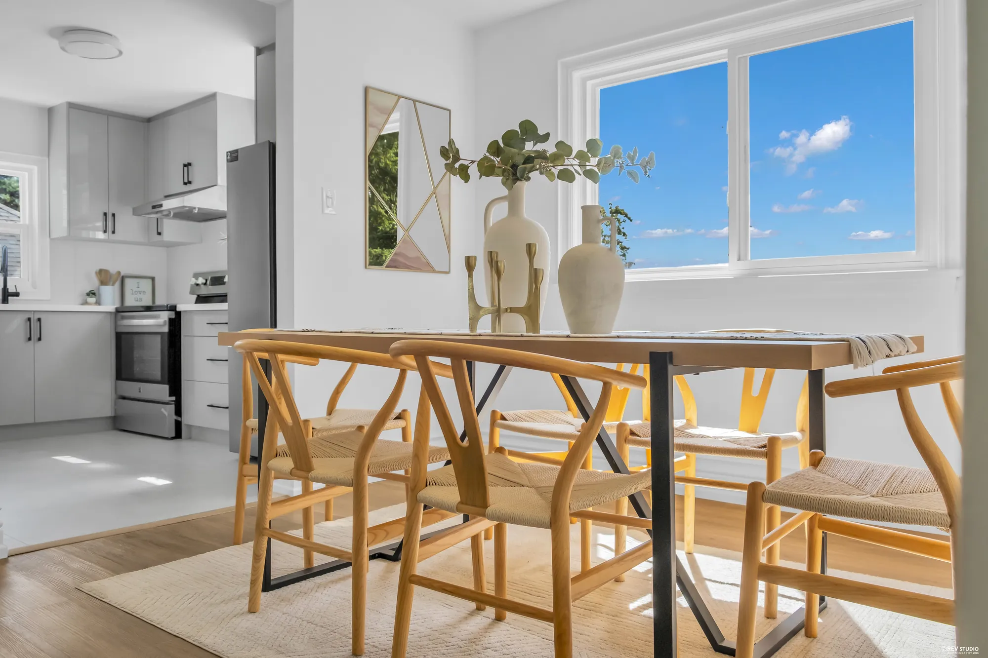 The dining table with the kitchen and its range visible through the doorway