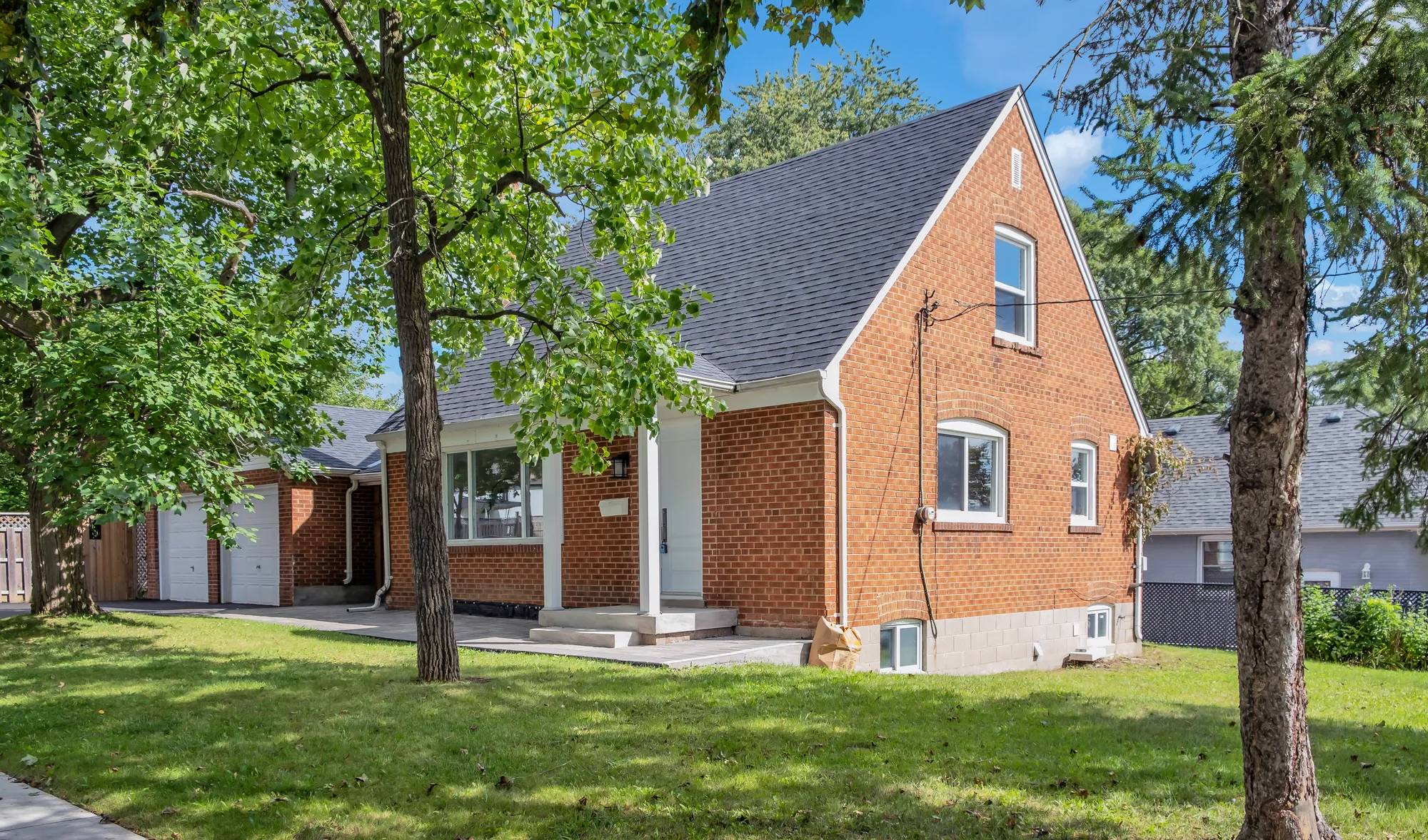 11 Harrow Drive from the front lawn, a red brick house framed by mature trees