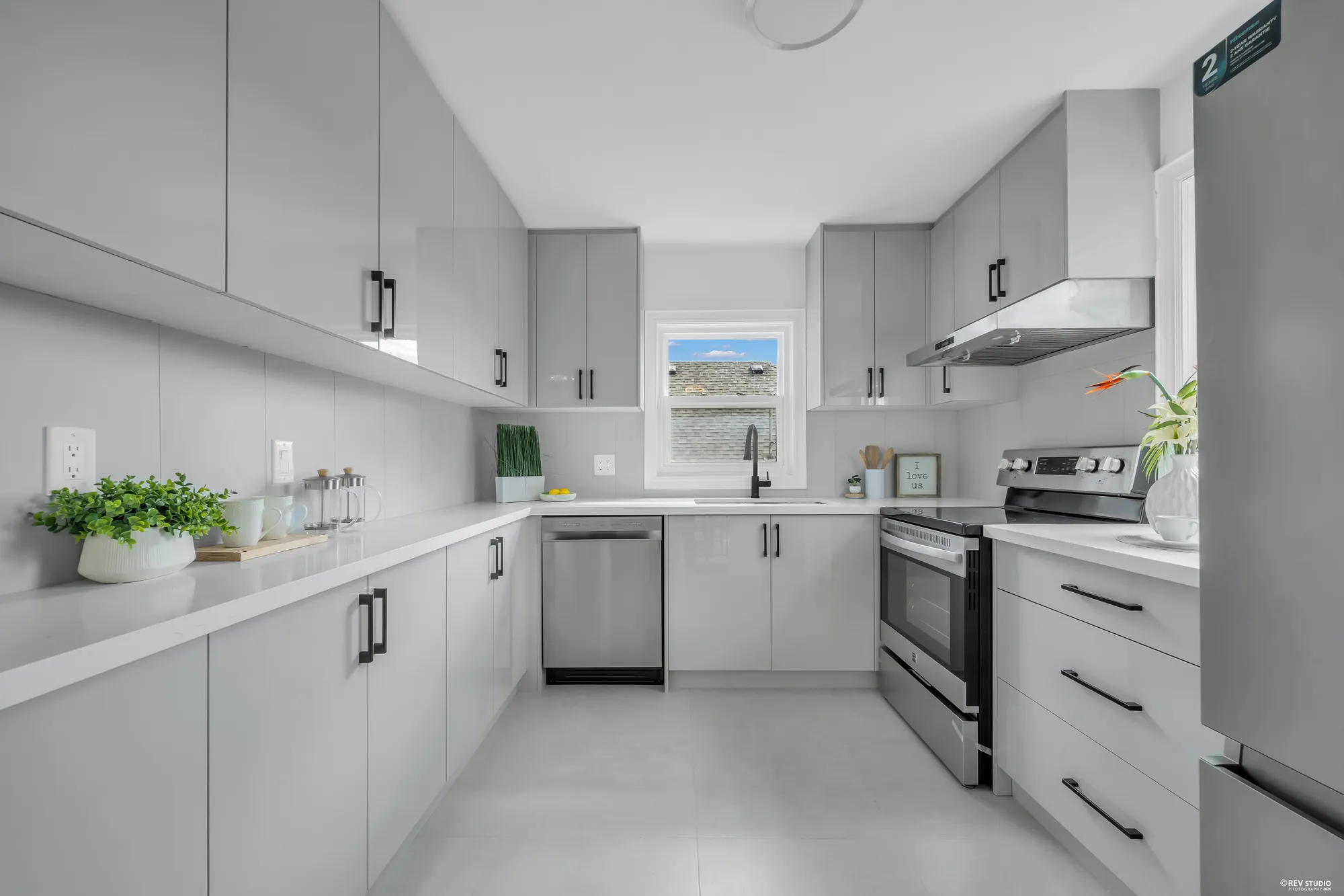 The kitchen from the other end showing the full run of cabinets and the dishwasher
