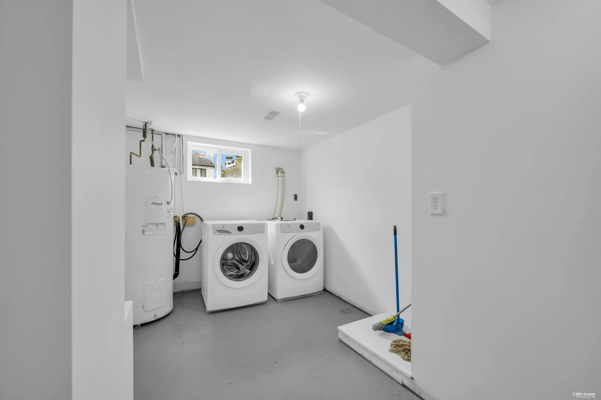 The laundry room with a washer, a dryer and the water heater