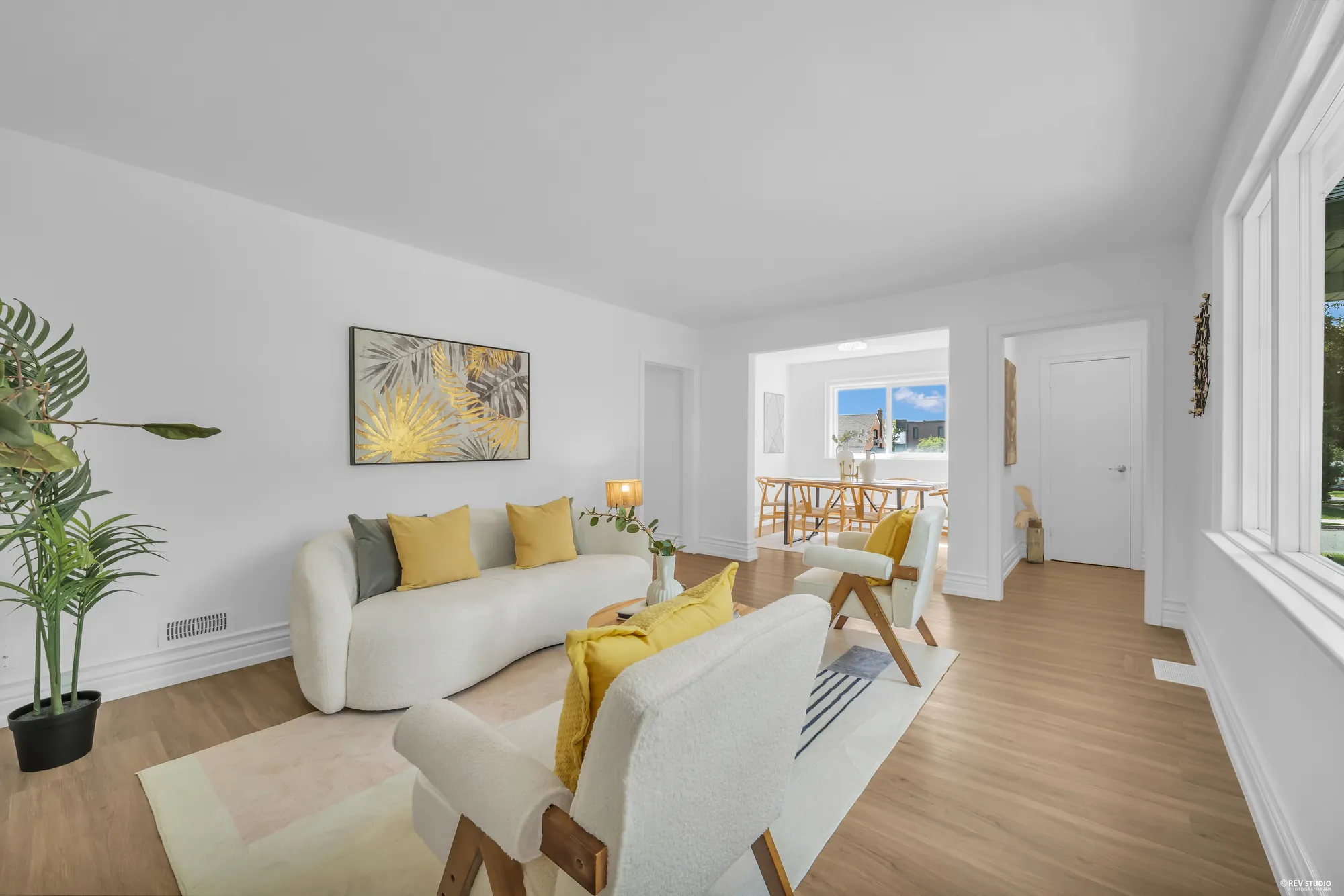 The living room along its length with the dining room and kitchen in line beyond