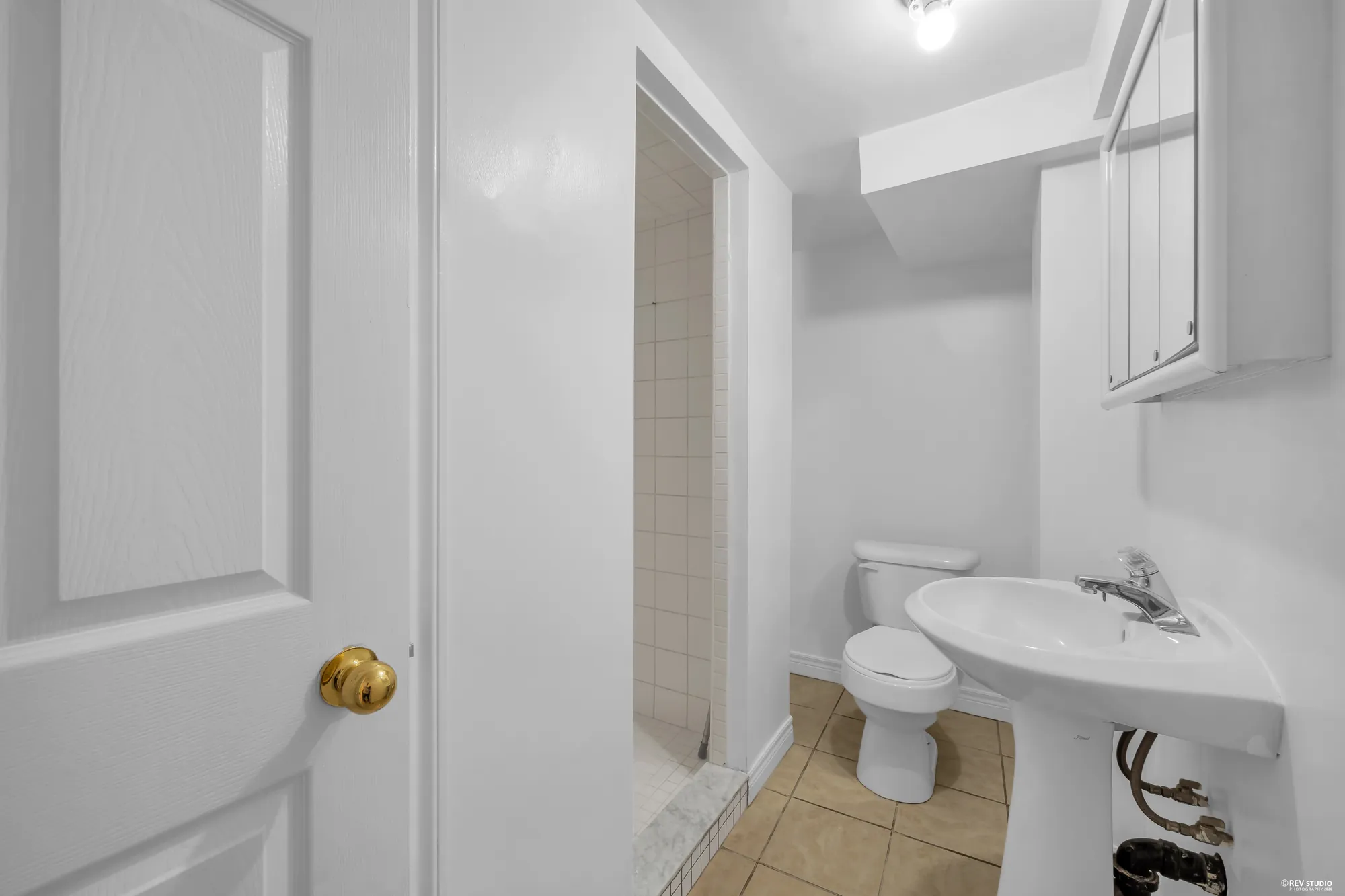 The three-piece bathroom on the lower level with a shower and a pedestal sink