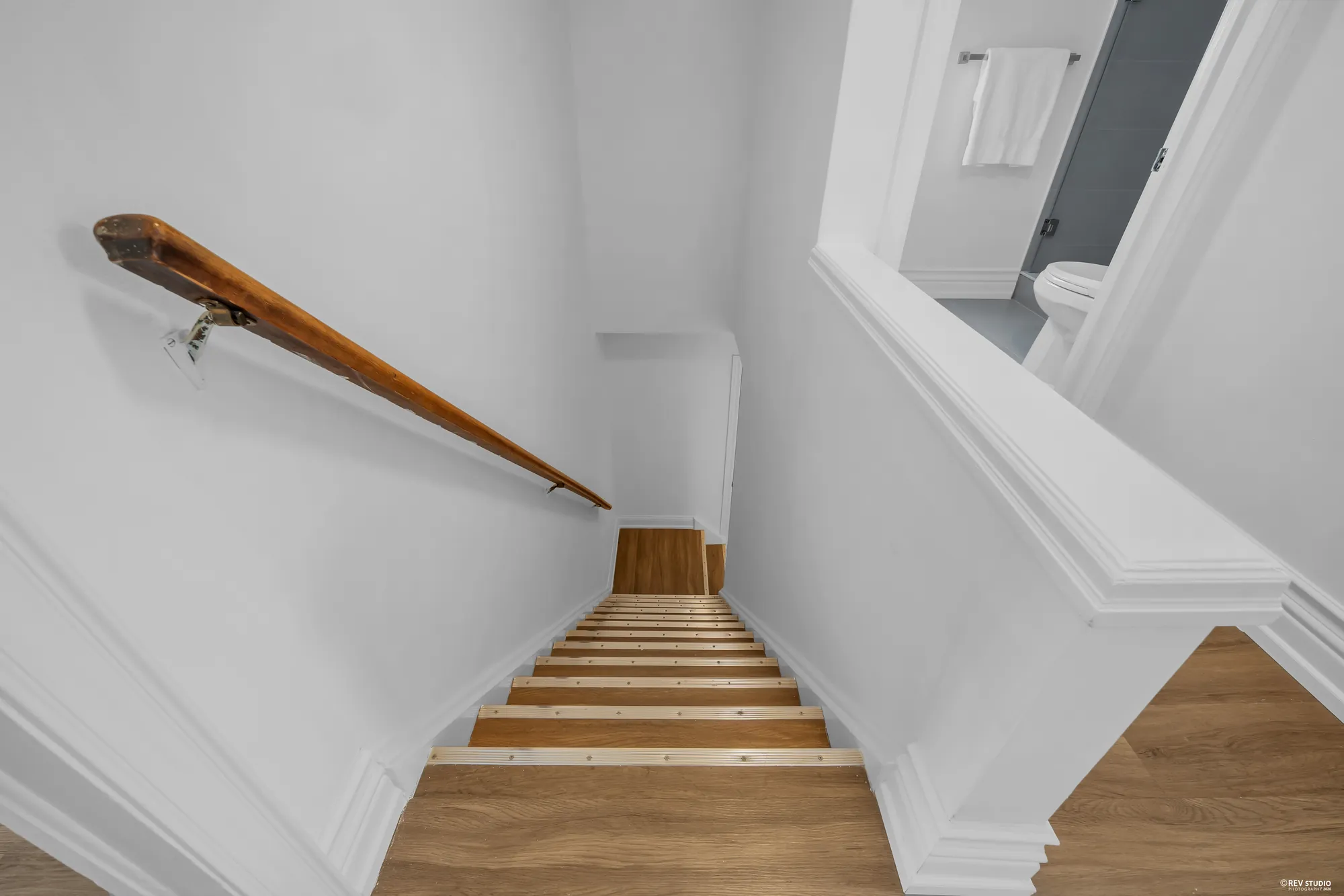 The staircase seen from the top, with the handrail along the wall